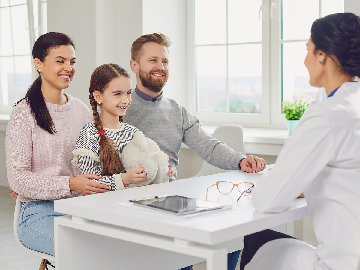 A doctor meeting with a daughter and her parents in the office. 